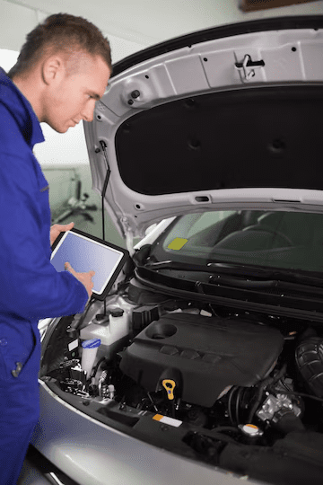 Mechanic testing the engine with a tablet computer Mechanic testing the engine with a tablet computer