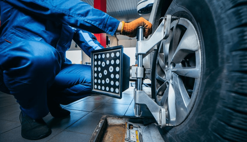 Auto mechanic installing sensor during suspension adjustment and automobile wheel alignment work Auto mechanic installing sensor during suspension adjustment and automobile wheel alignment work