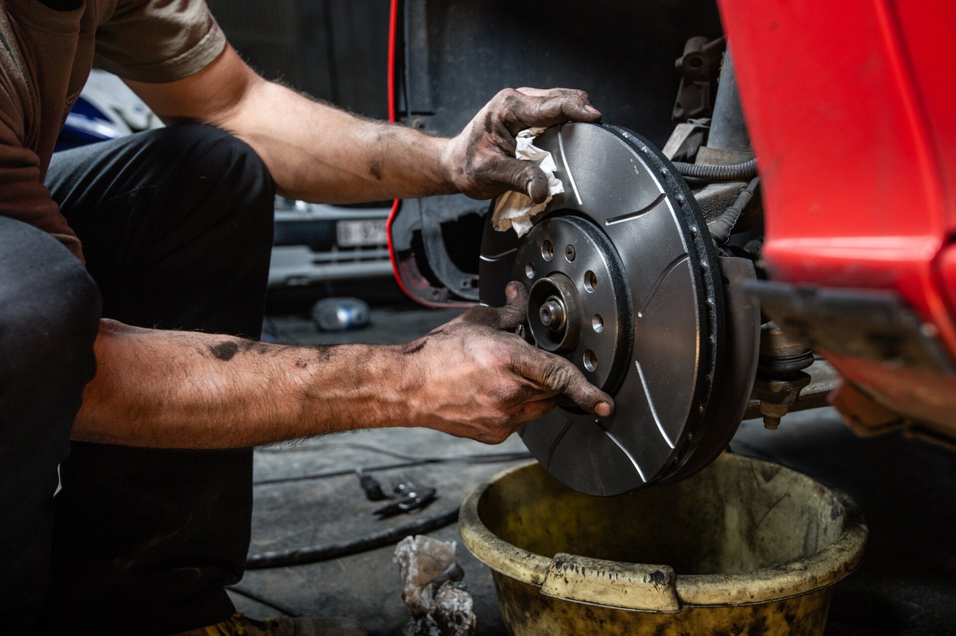 Close up of a man's hands placing some brake discs Close up of a man's hands placing some brake discs