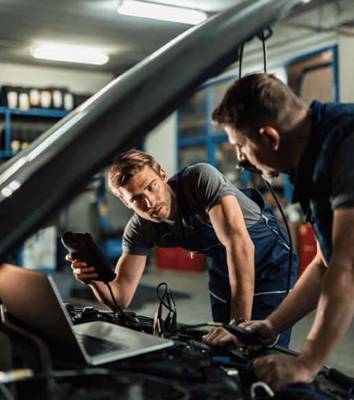 young-car-repairman-talking-with-his-coworker-while-checking-engine-performance-with-diagnostic-tools-auto-repair-shop young car repairman talking with his coworker while checking engine performance with diagnostic tools auto repair shop